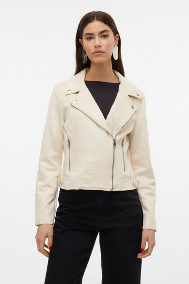 Beige leren jas van Vero Moda, gedragen met een zwarte top en zwarte broek, met zilverkleurige ritsen.