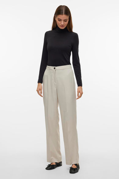 Beige broek van VERO MODA, gecombineerd met een zwarte coltrui en zwarte ballerina's.