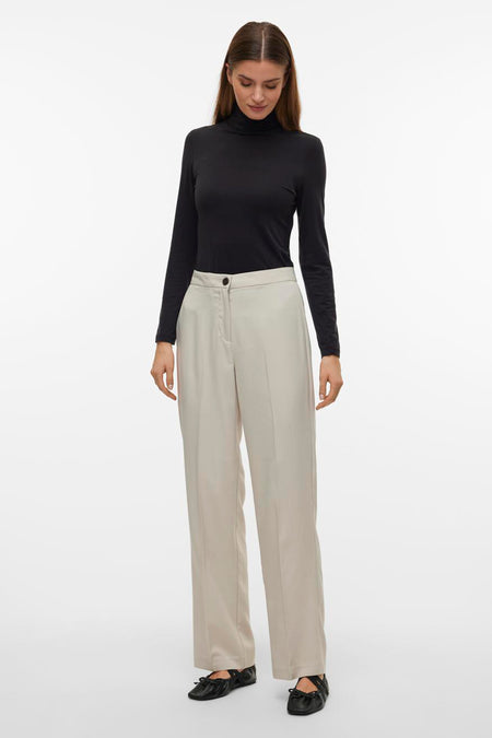 Beige broek van VERO MODA, gecombineerd met een zwarte coltrui en zwarte ballerina's.