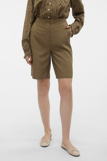 Bruine short van VERO MODA, met een hoge taille, gecombineerd met een geborduurde blouse en beige ballerina's.

