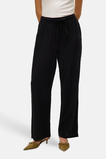 Pantalon noir de VERO MODA, avec cordon de serrage et associé à des chaussures vert olive.