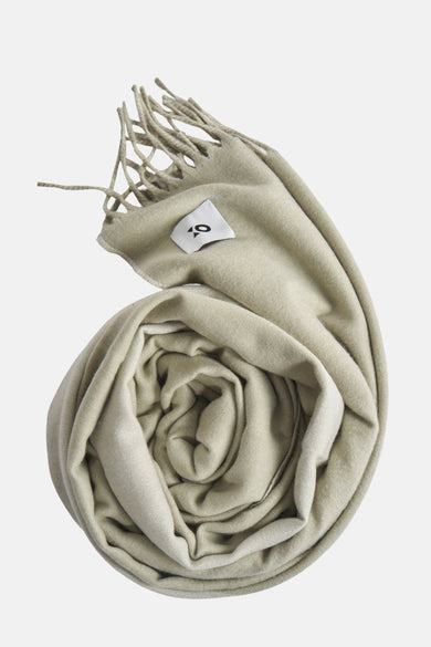 Opgeslagen, beige sjaal met franjes en label.
