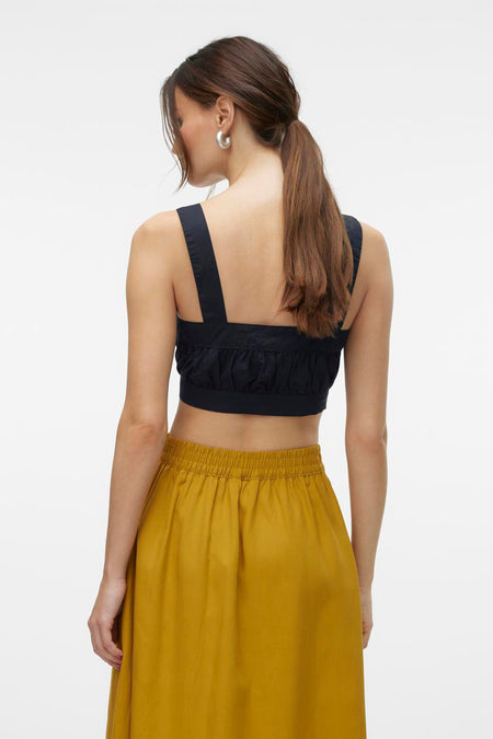 Zwarte blouse van VERO MODA, met bandjes en een gerimpelde taille, gecombineerd met een okergele rok.