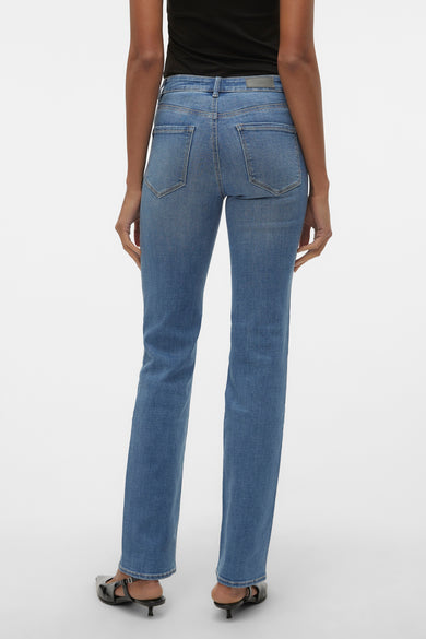 Rechte jeans van blauw denim van VERO MODA, achterzijde getoond, met achterzakken en zwarte schoenen.
