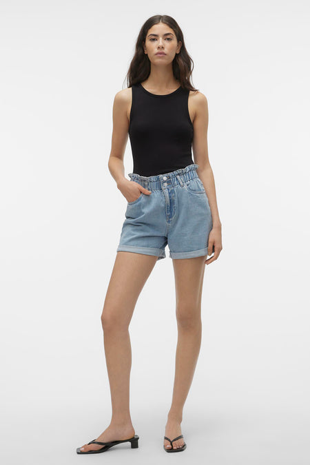 Lichtblauwe denim short van VERO MODA® met een ruchetaille en opgerolde pijpen, gecombineerd met een zwarte top en sandalen.