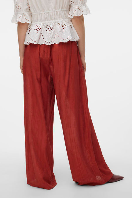 Bruine broek van Vero Moda met verticale lijnen, gezien van achteren, gecombineerd met een witte blouse.
