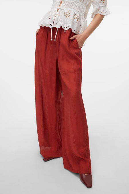Pantalon marron de VERO MODA, avec cordon et lignes verticales, associé à une blouse blanche.