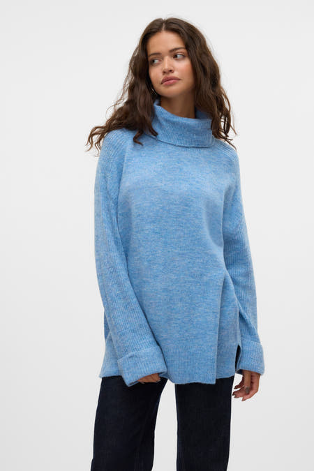 Blauwe trui met rolkraag van VERO MODA, zachte textuur, lange mouwen en gedragen met donkere jeans.