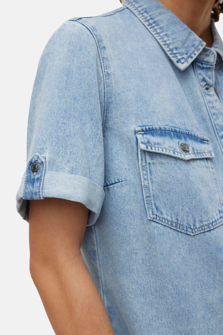 Lichtblauw denim kleedje met korte mouwen van VERO MODA, met een borstzak en opgerolde mouwen.
