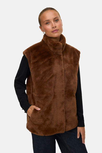 Bruine bodywarmer van VERO MODA®, met opstaande kraag en een hand in de zak gestoken.