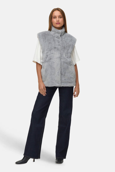 Gilet gris de VERO MODA®, porté sur un t-shirt blanc avec des jeans foncés et des baskets noires.