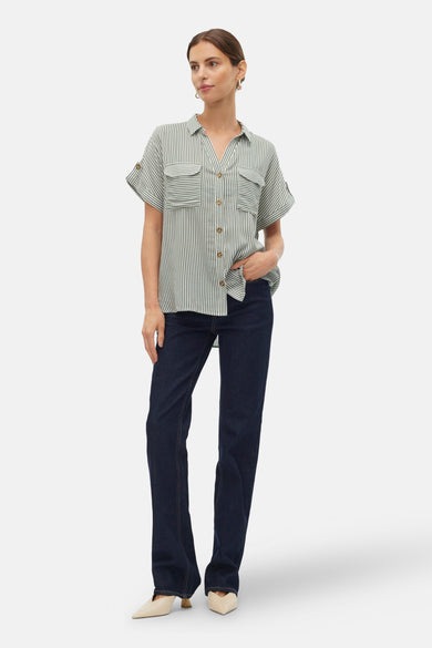 Groen gestreept hemd met korte mouwen van VERO MODA, met knoopsluiting en opgestikte zakken, gedragen met donkere jeans en hakken.