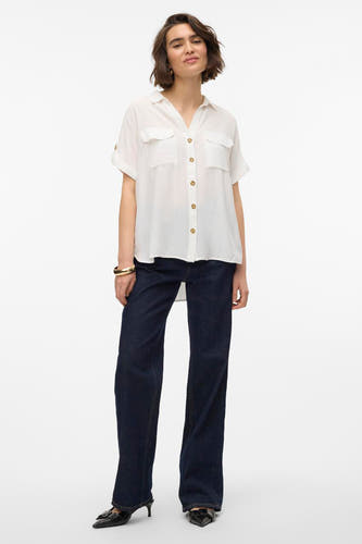Wit, kort mouwen hemd van VERO MODA®, met knoopsluiting en zakken, gecombineerd met donkere jeans en zwarte pumps.