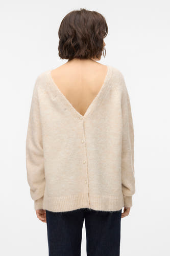 Pull beige à col rond de VERO MODA, avec longues manches et détail de bouton sur le dos, associé à un pantalon foncé.