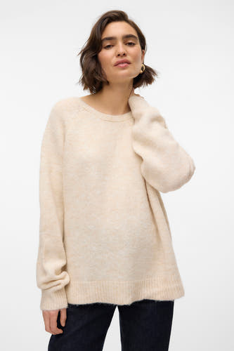 Pull beige à col rond de VERO MODA, avec des manches longues et porté avec un pantalon foncé.