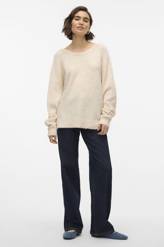 Gilet rond beige de VERO MODA porté avec des jeans larges et sombres et des ballerines bleues.