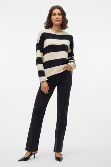 Gilet rond col noir VERO MODA® avec des rayures crème, associé à des jeans noirs et des bottes noires.