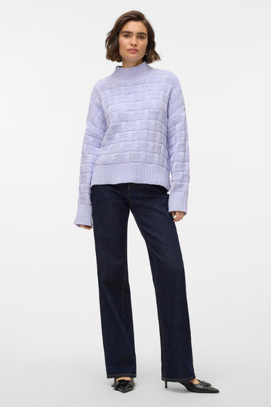 Paarse coltrui van VERO MODA®, met een geweven patroon, gecombineerd met donkere, wijde jeans en zwarte hakken.
