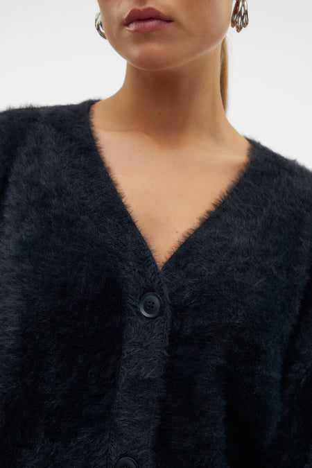 Gilet noir doux de VERO MODA® avec col en V, texture veloutée et boutons foncés, gros plan sur le devant