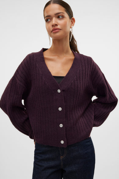 Bordeaux coltrui van VERO MODA, met lange mouwen, en gedragen met een zwarte top en donkerblauwe jeans.
