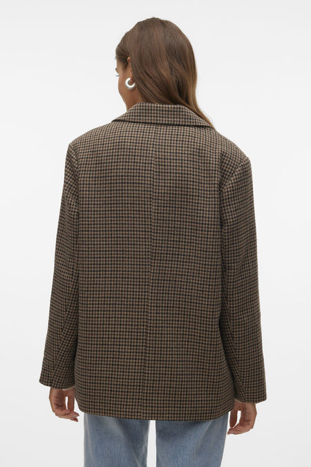 Bruine blazer van VERO MODA met een houndstooth motief, gedragen over een jeans.
