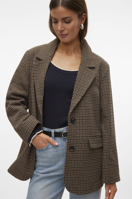 Bruine blazer van VERO MODA® met pied-de-poulepatroon, gecombineerd met blauwe jeans en een zwart shirt.
