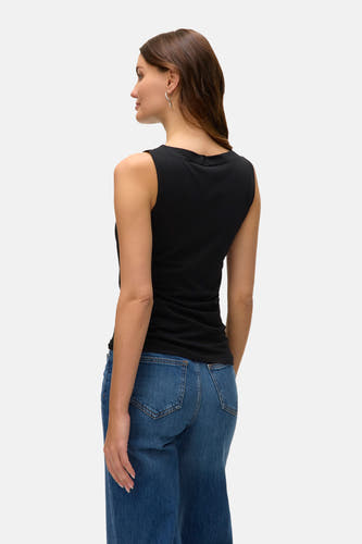 T-shirt sans manches noir de VERO MODA, avec un col rond et associé à des jeans bleus.