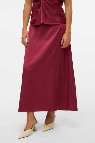 Rode rok van VERO MODA, met een satijnen textuur, gecombineerd met een rood topje en beige muiltjes.