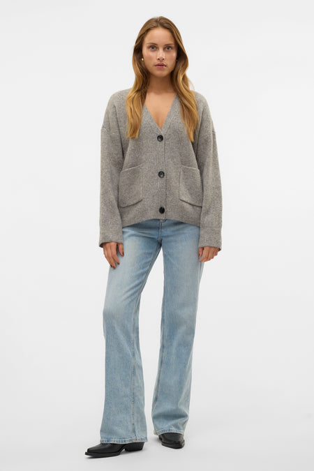 Grijs vest van VERO MODA, met knoopsluiting, zakken en gecombineerd met blauwe jeans en zwarte laarzen.

