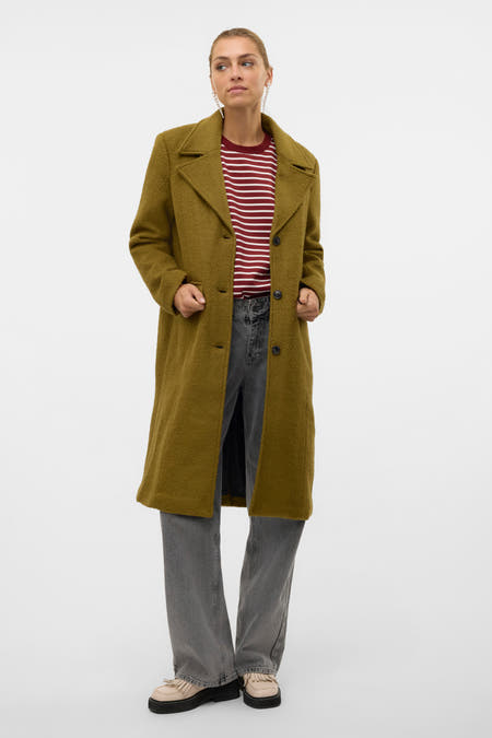 Groene lange jas van Vero Moda, met knoopsluiting en gedragen over een gestreepte top en grijze jeans.