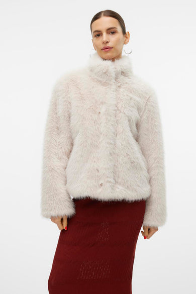 Mauve court manteau de Vero Moda, avec une douce texture fausse fourrure, porté avec des manches côtelées et des boucles d'oreilles.