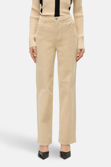 Ecru broek van VERO MODA®, uitgevoerd in ribstof en gecombineerd met een beige trui en zwarte pumps.
