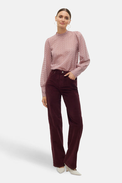 Bordeaux broek van VERO MODA®, met een corduroy textuur en wijde pijpen, gecombineerd met een roze blouse.

