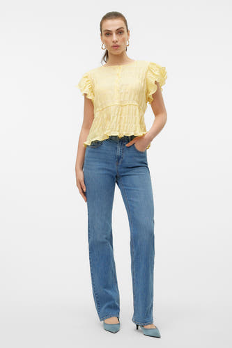 Jean bleu droit de VERO MODA, avec des escarpins en cuir bleu et une blouse jaune.