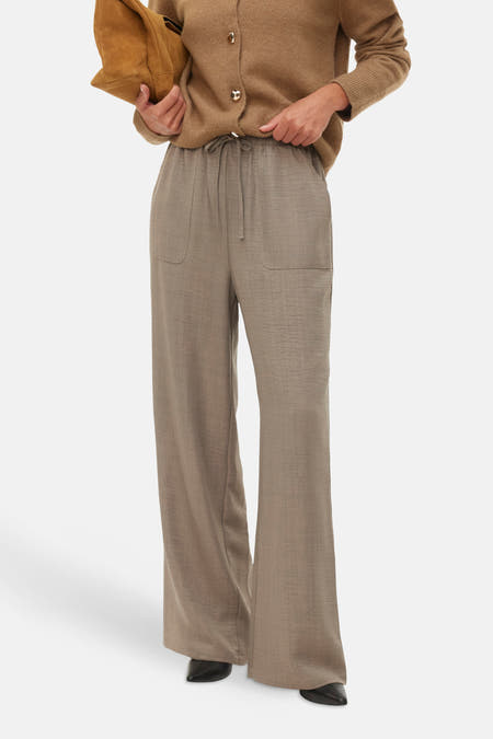 Jean brut VERO MODA® avec cordon et larges jambes, associé à un pull tricoté et une sacoche.