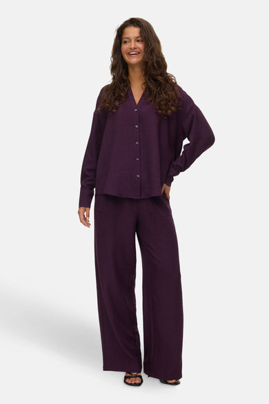 Pantalon de couleur marron de VERO MODA, porté avec une blouse coordonnée et des sandales.