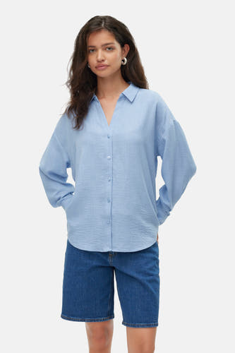 Blau,, manche man chemis V VERO MODAA portée sur sur top noir et des short de denim.