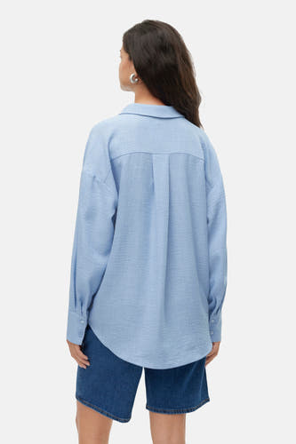 Chemise bleue à manches longues de VERO MODA, vue de derrière, avec des plis et des shorts en denim.