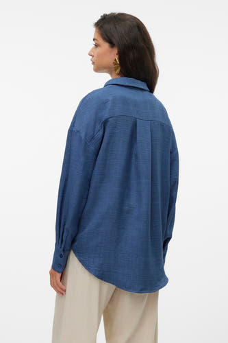 Blauw overhemd met lange mouwen van VERO MODA, met plooien op de rug en gedragen met beige broek.