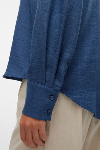 Blauw hemd met lange mouwen van VERO MODA®, getoond met twee knopen aan de manchet.