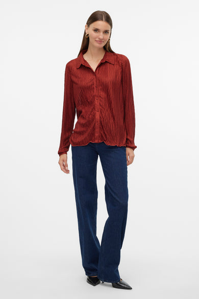 Rood, lang mouwen hemd van VERO MODA®, met een subtiele textuur, gecombineerd met een donkere spijkerbroek en zwarte schoenen.
