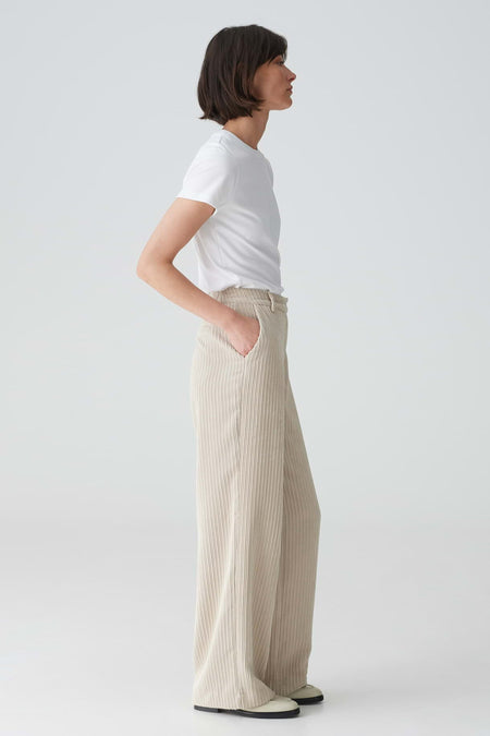 Beige broek van OPUS met wijde pijpen en plissétextuur, gedragen door model.