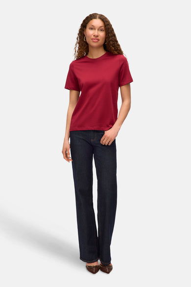 Rood T-shirt met korte mouwen van VERO MODA, gecombineerd met donkerblauwe jeans en bruine schoenen.