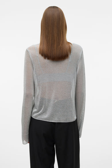 Zilverkleurige trui met ronde hals van VERO MODA, met lange mouwen en zwarte pantalon.
