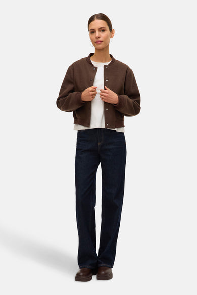Bruine korte jas van VERO MODA, gedragen met een wit T-shirt en donkerblauwe jeans.