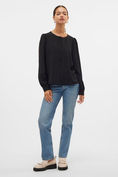 Zwarte blouse met lange mouwen van VERO MODA, met knoopsluiting, gedragen met blauwe jeans en crèmekleurige schoenen.