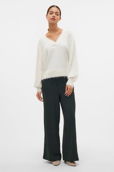 Pantalon vert de VERO MODA, avec des jambes larges et une ceinture élastique, porté avec un pull blanc.