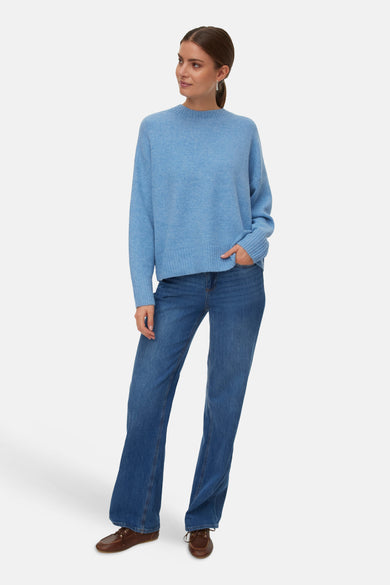Blauwe trui met ronde hals van VERO MODA, gecombineerd met blauwe jeans en bruine schoenen.
