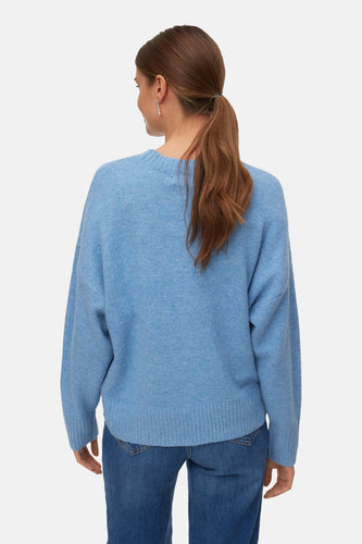 Blauwe trui met ronde hals van VERO MODA®, achterkant met lange mouwen en jeans.
