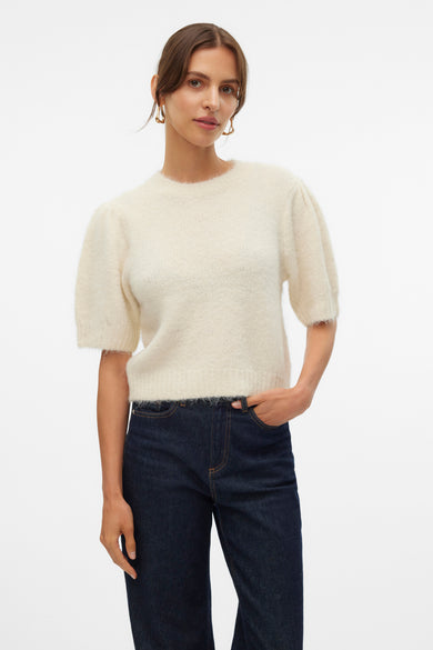 T-shirt écru avec col rond de VERO MODA, à manches ballon, associé à des jeans noirs et des boucles d'oreilles dorées.